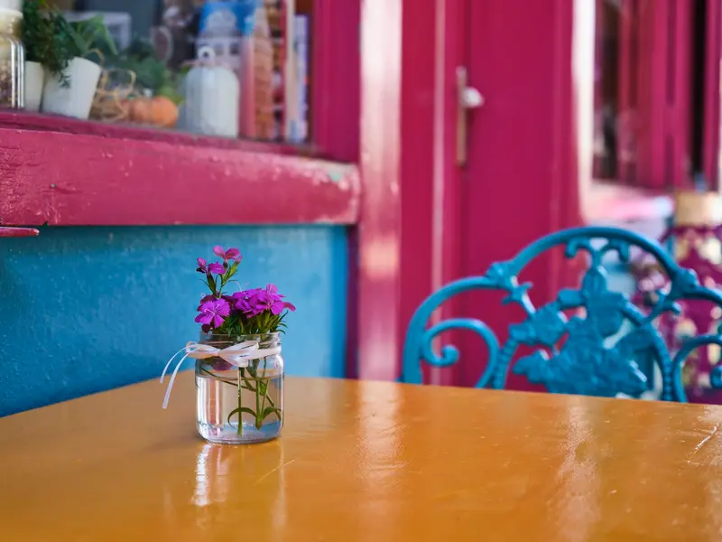 Pink and turquoise chairs in a colourful dining room