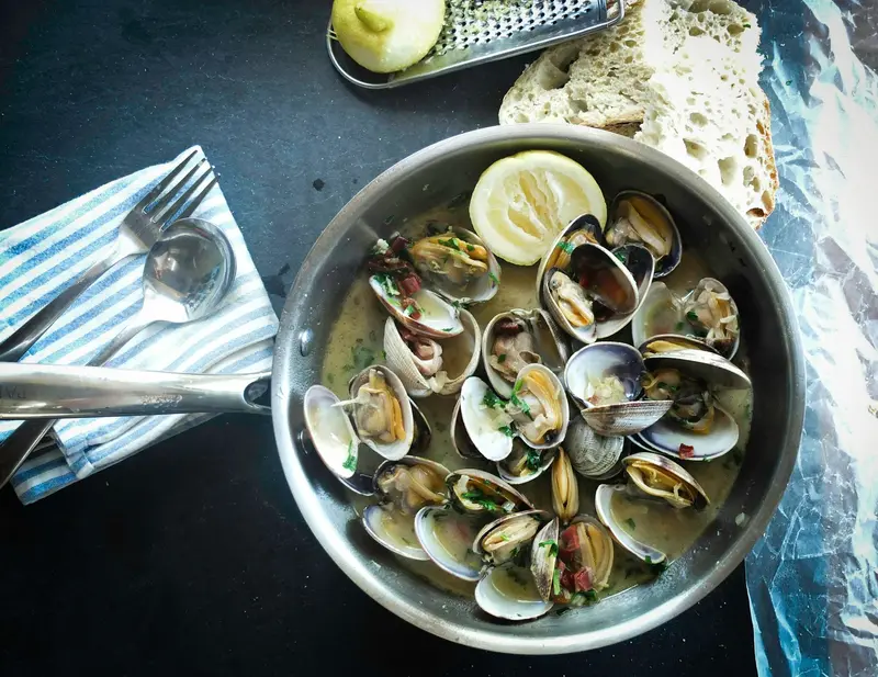 A pan of clams with lemon and bread