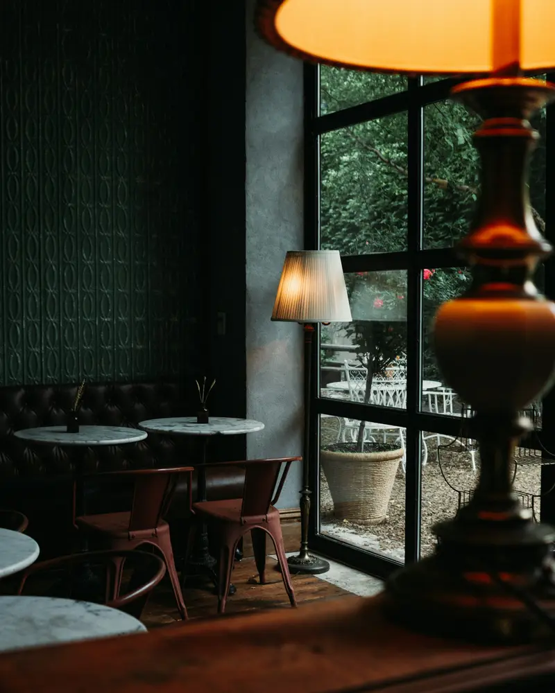 A dark dining room lit by small table lamps