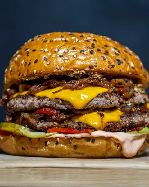 Cheeseburger with pickles on a dark background
